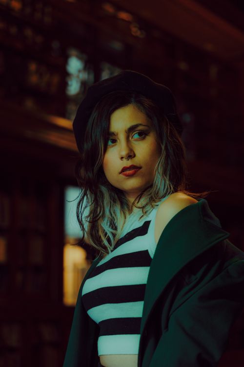 Free Portrait of a fashionable woman in a beret and striped top, exuding a chic vibe indoors. Stock Photo