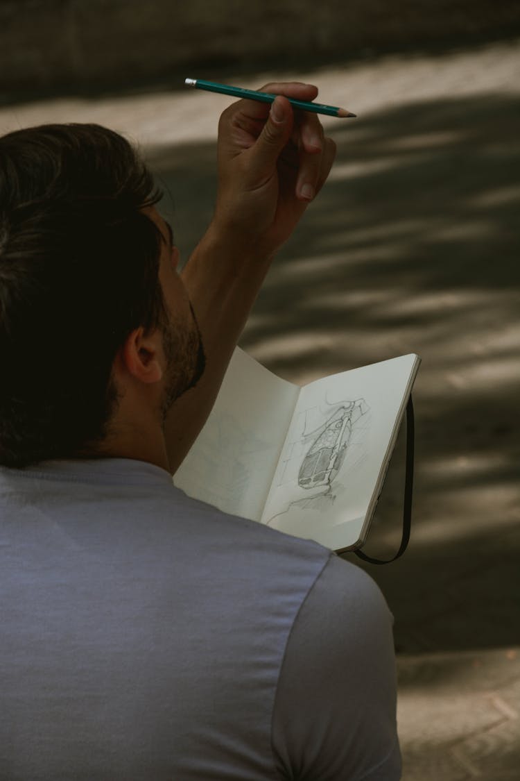 Man Holding Green Pencil