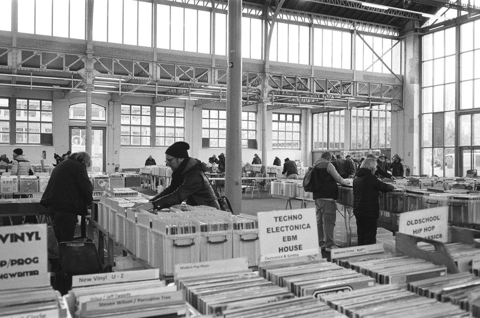Black and white photo of people browsing records at a vintage store in Nancy, France.