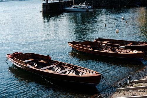 Free Wooden rowboats floating on Lake Maggiore's calm waters in Laveno-Mombello, Italy. Stock Photo