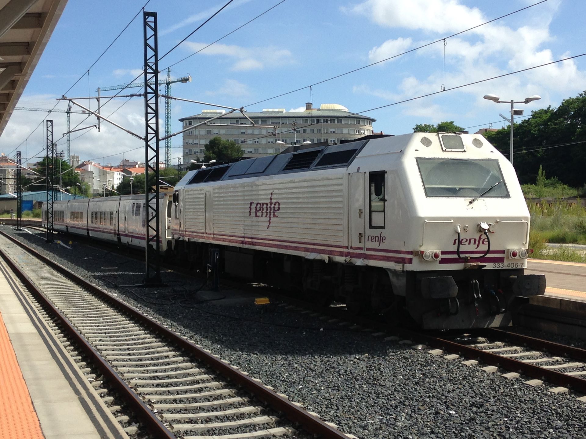 Renfe train stationed at Vigo platform under a clear sky, showcasing modern rail travel.