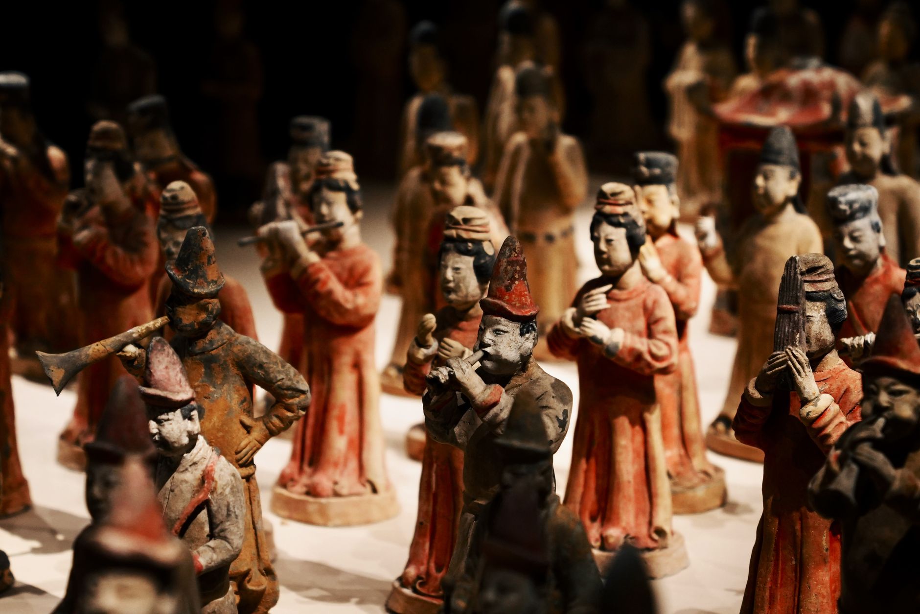 Close-up of ancient Chinese terracotta musician figurines in traditional attire on display.