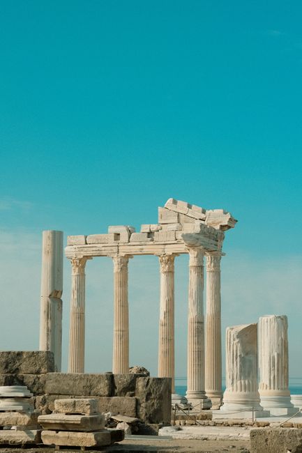 Explore the majestic ruins of an ancient temple with Corinthian columns and clear blue skies.