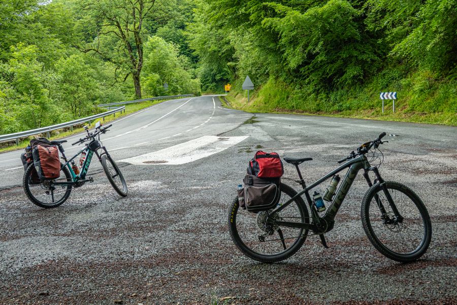 Two bicycles parked on a forest road, surrounded by lush greenery, ideal for travel and adventure enthusiasts.