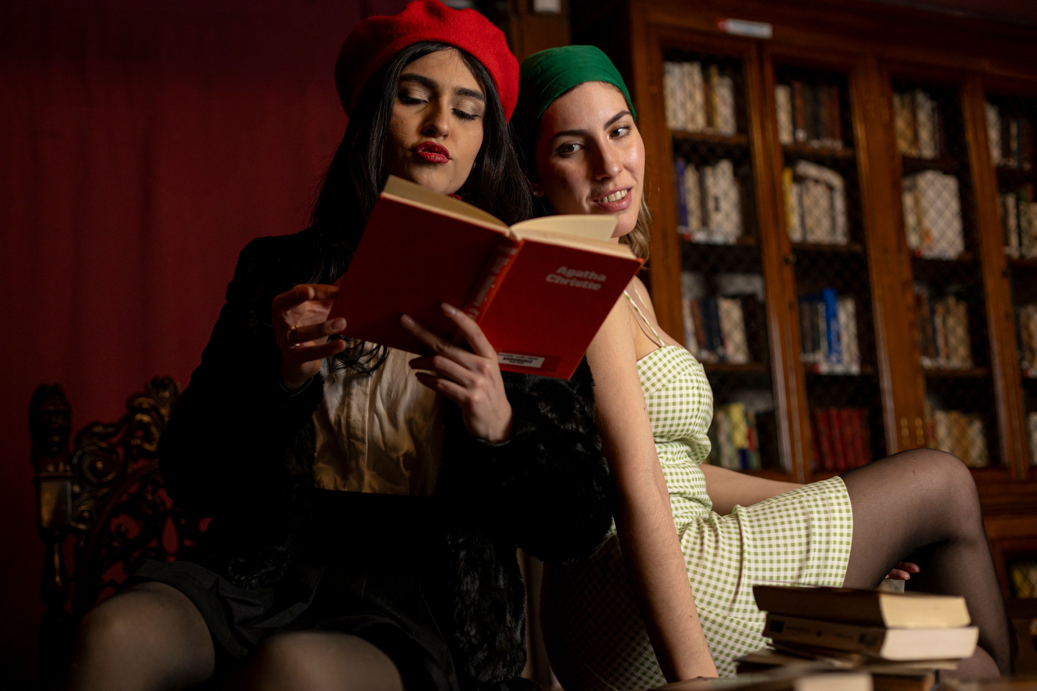 Gratis Due donne che leggono in una biblioteca di Buenos Aires indossando abiti eleganti. Foto a disposizione