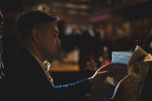 Free A man reading a newspaper in a dimly lit Buenos Aires cafe, creating an intimate ambiance. Stock Photo