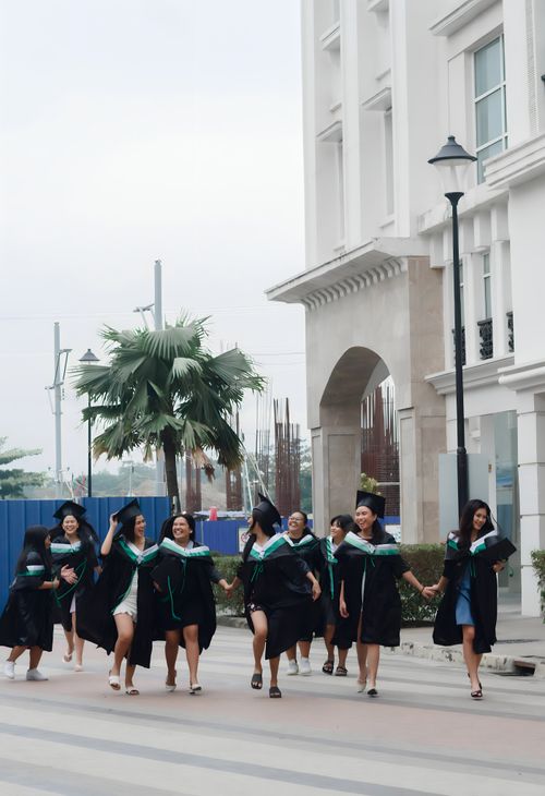 Free Group of young graduates celebrating their achievement outdoors. Stock Photo