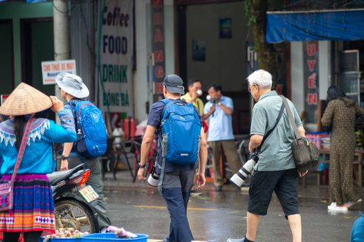 Photographers capturing vibrant scenes at Bắc Hà market, showcasing local culture in Lào Cai, Vietnam.