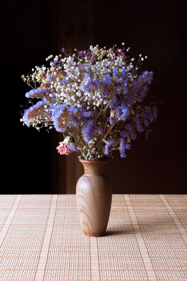 Dried flowers in a turned wooden vase — photo by Dominykas on Pexels