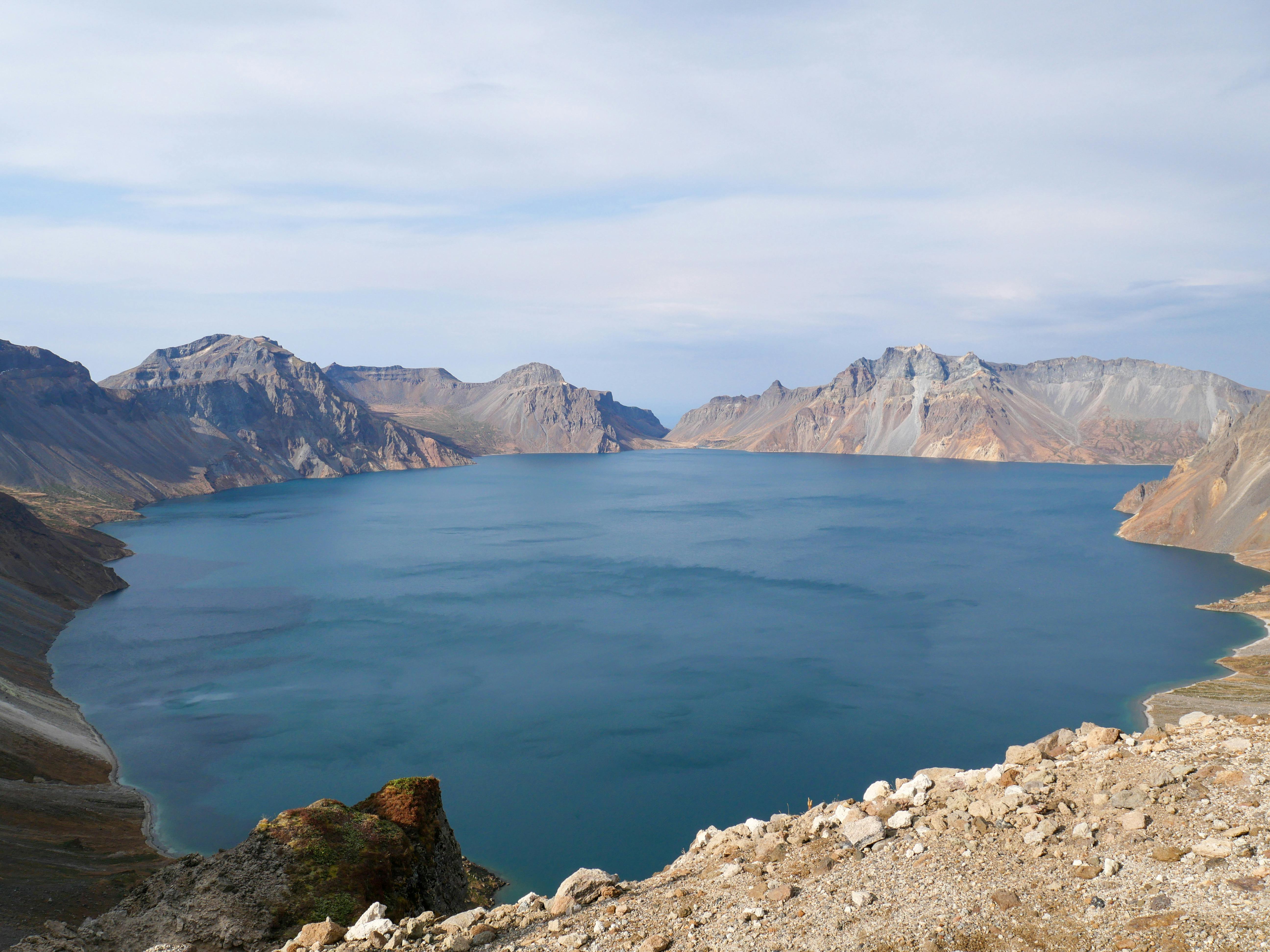 Heavenly Lake Tianchi volcanic crater lake surrounded by snow-capped Changbai Mountain peaks at sunrise