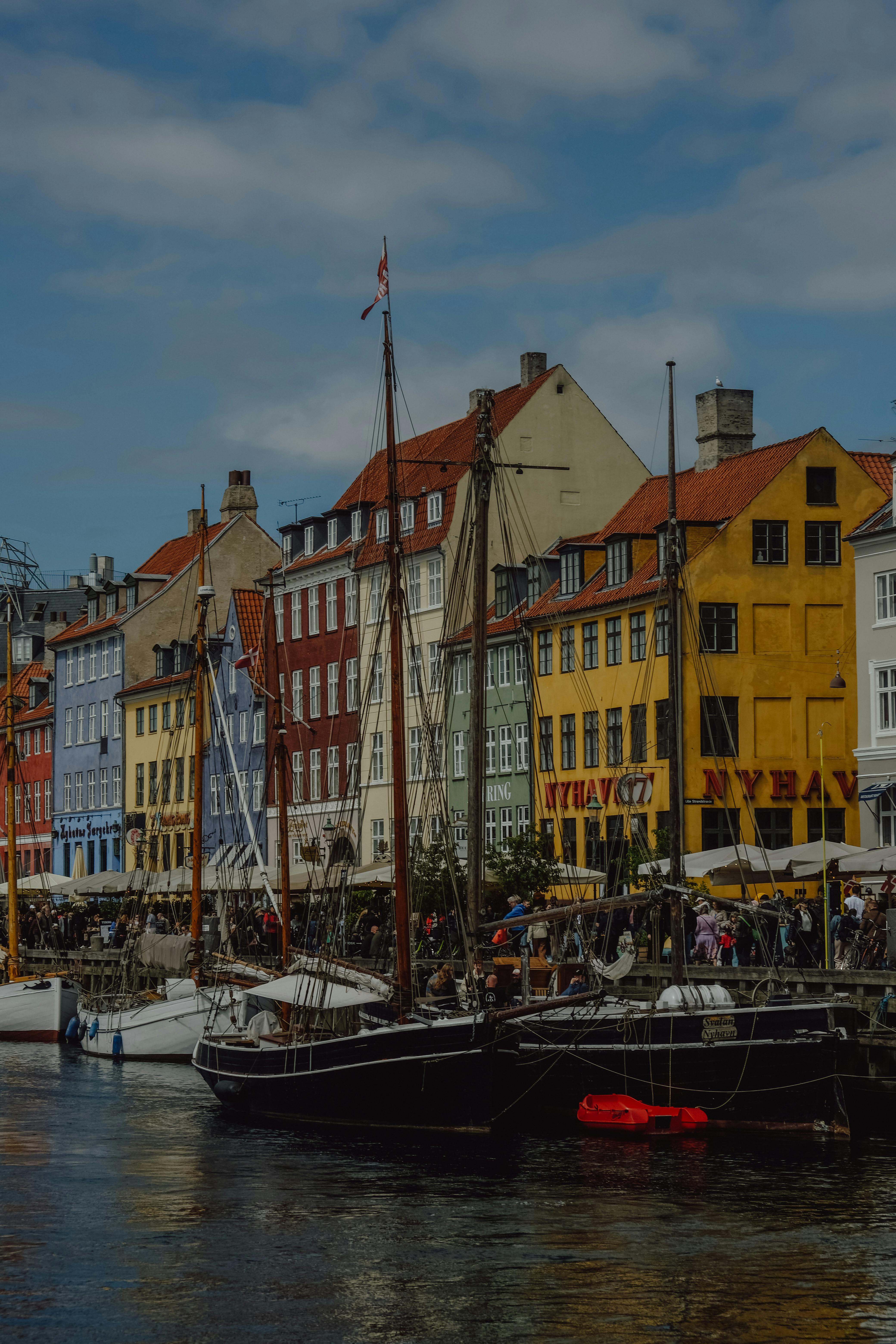 Charming view of Nyhavn canal with colorful buildings and historic boats in Copenhagen's scenic harbor.