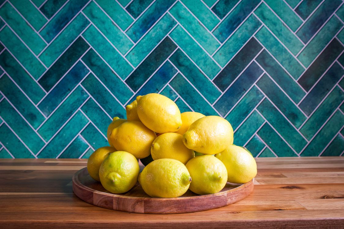 Stack Lemoons Fresh Lemons on Wooden Tray Against Teal Background · Free Stock Photo