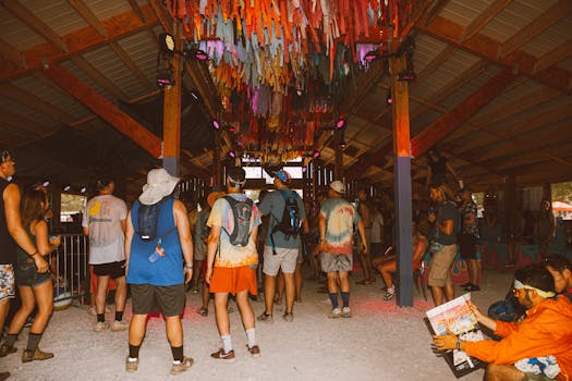 热闹的人群在色彩缤纷的室内节日中享受着充满活力的装饰和扎染服装