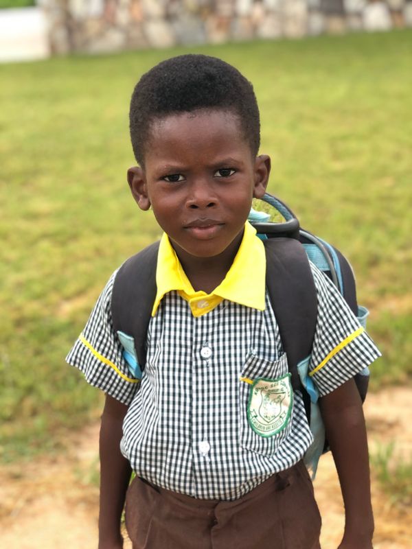 Young boy in school uniform with backpack