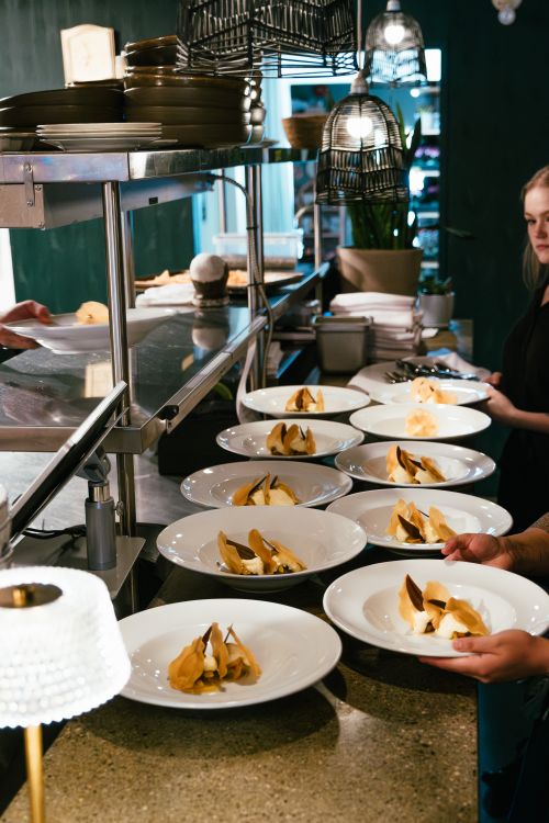 Free Fine dining setup with elegant plating of gourmet dishes in a professional kitchen environment. Stock Photo