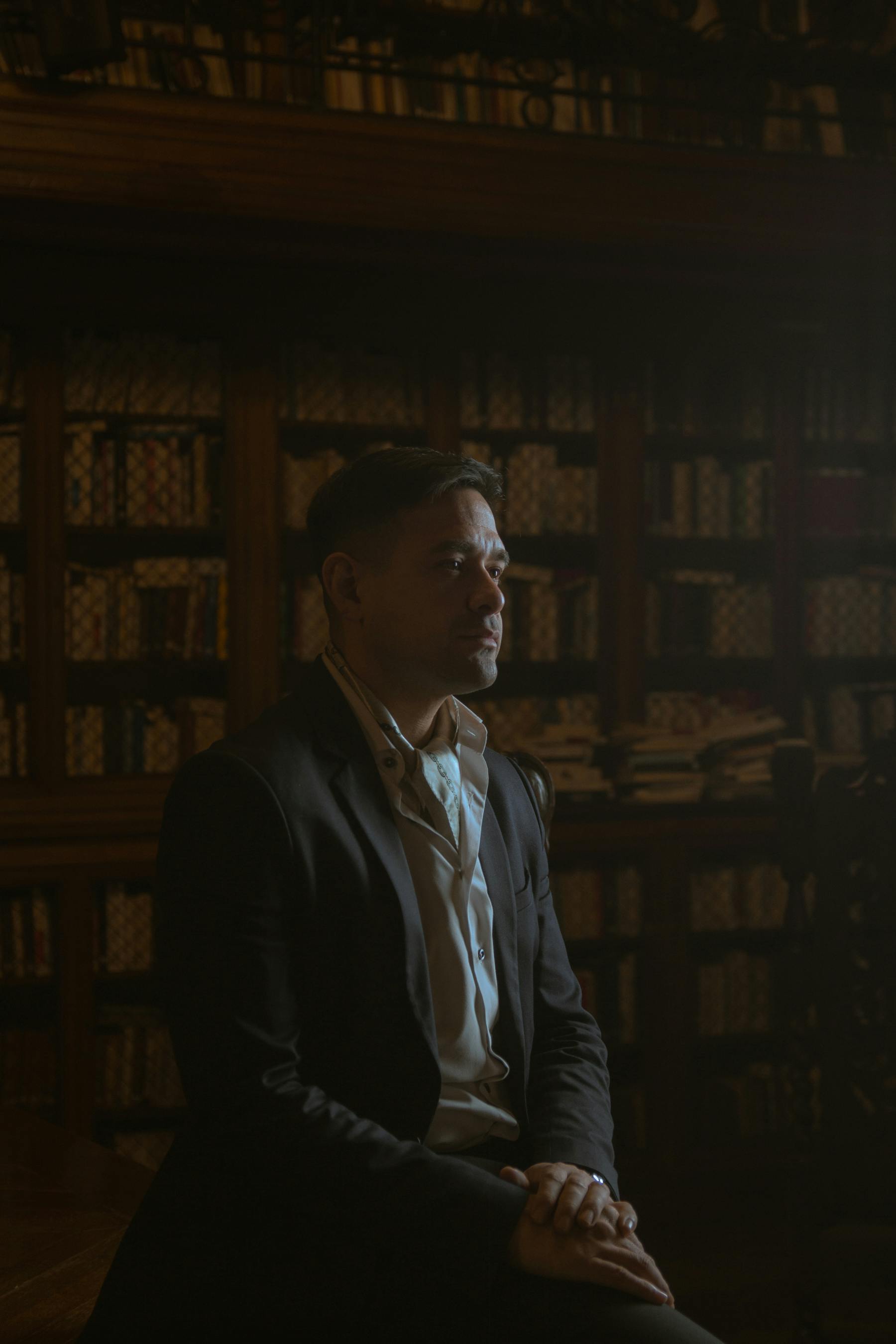 Gratis Sofisticato ritratto di un uomo adulto in una biblioteca scarsamente illuminata di Buenos Aires. Foto a disposizione