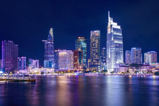 Stunning nighttime view of Ho Chi Minh City's skyline reflecting on the Saigon River.