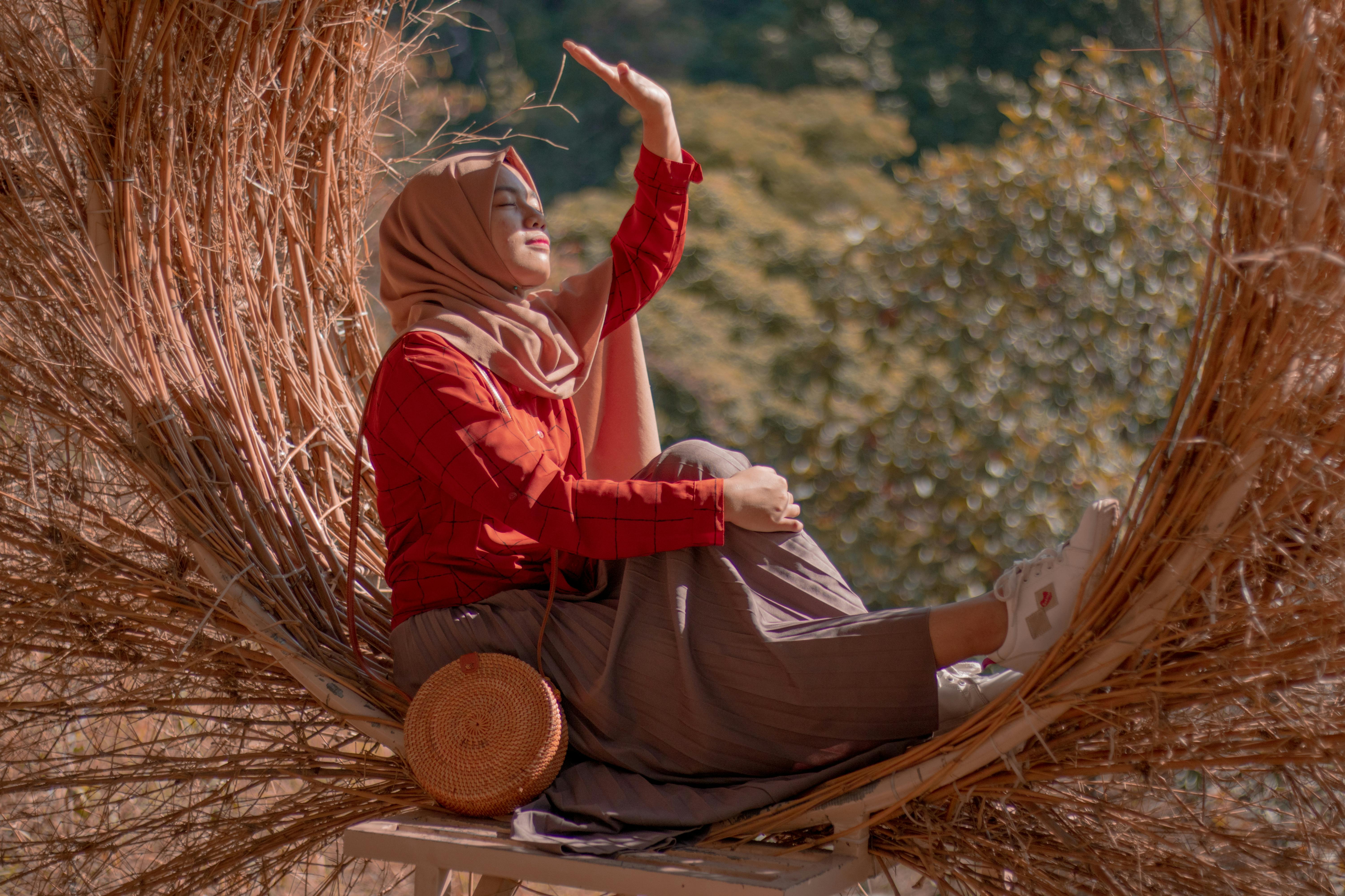 A serene portrait of a woman in nature, enjoying the sunlight and peaceful surroundings.