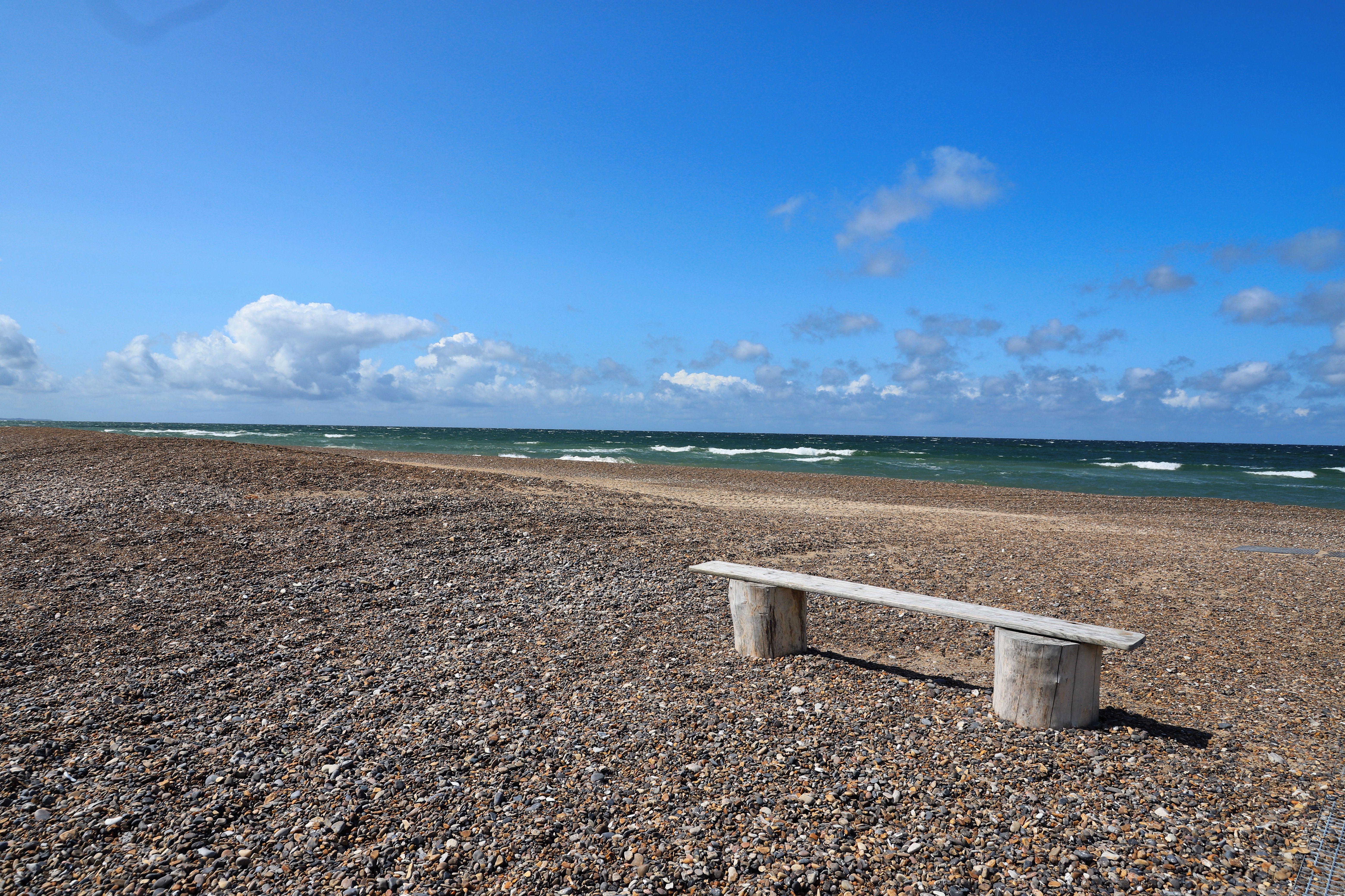 Empty Bench on Pebble Beach in Denmark · Free Stock Photo