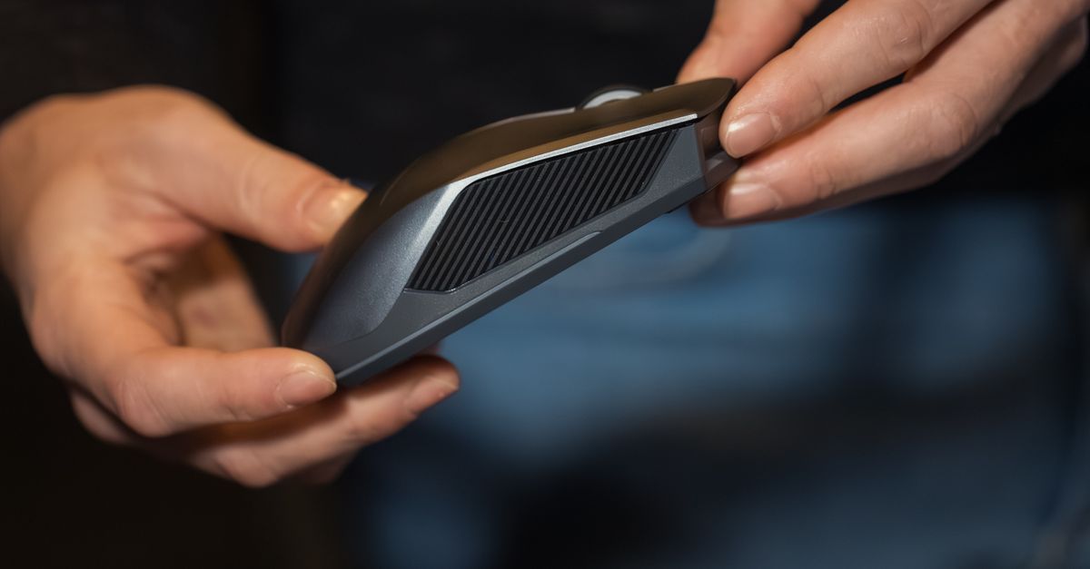 Person Holding Ergonomic Wireless Mouse in Hand · Free Stock Photo