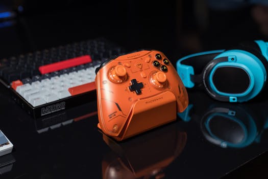 Dynamic gaming setup featuring an orange controller, keyboard, and blue headset.