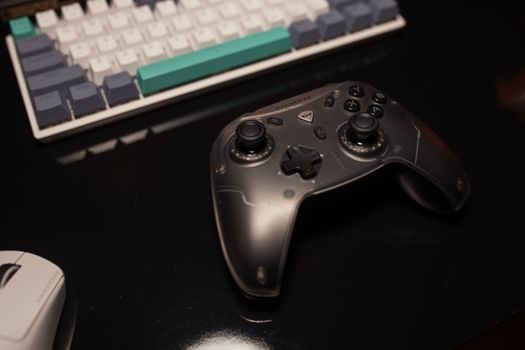 Close-up of a gaming controller on a desk with a keyboard and mouse, perfect for gamers.