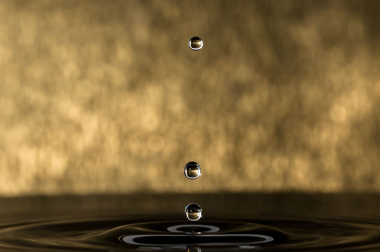 artistic macro shot of water droplets against a gold background showca