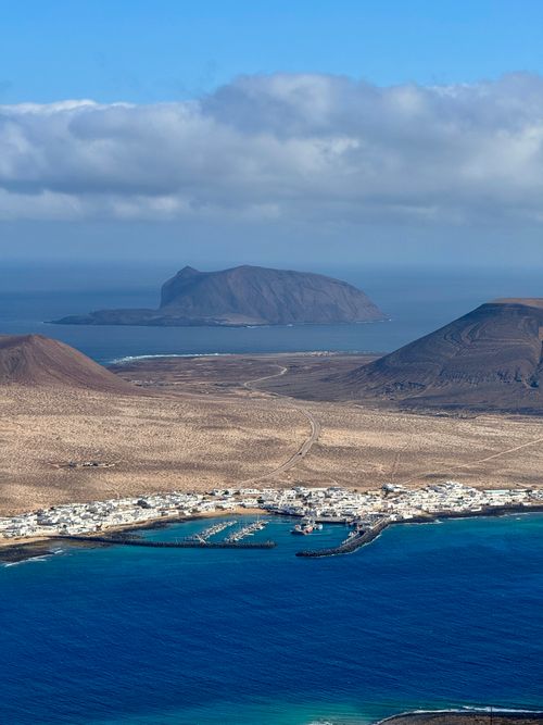 Free A breathtaking aerial photograph of La Graciosa island from Lanzarote, showcasing natural beauty and ocean contrast. Stock Photo