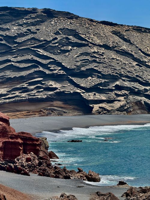 Free Dramatic volcanic cliffs and azure ocean waves at Lanzarote's stunning coastline. Stock Photo
