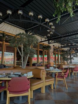 A stylish, contemporary cafe featuring comfortable seating and lush indoor plants.