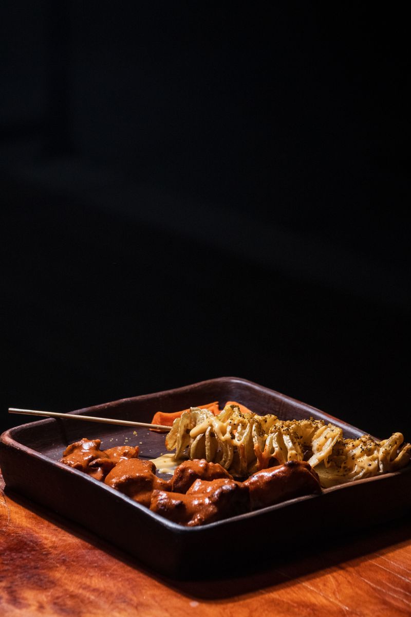 Delicious grilled skewers of meat and vegetables on a dark plate, perfect for barbecue lovers.