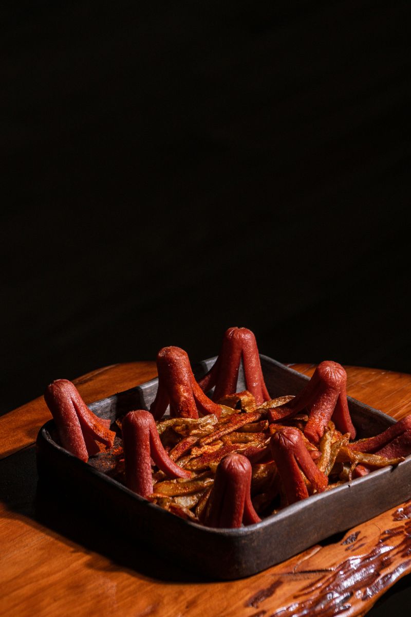 Unique presentation of sausage octopus on fries, perfect for a fun culinary experience.