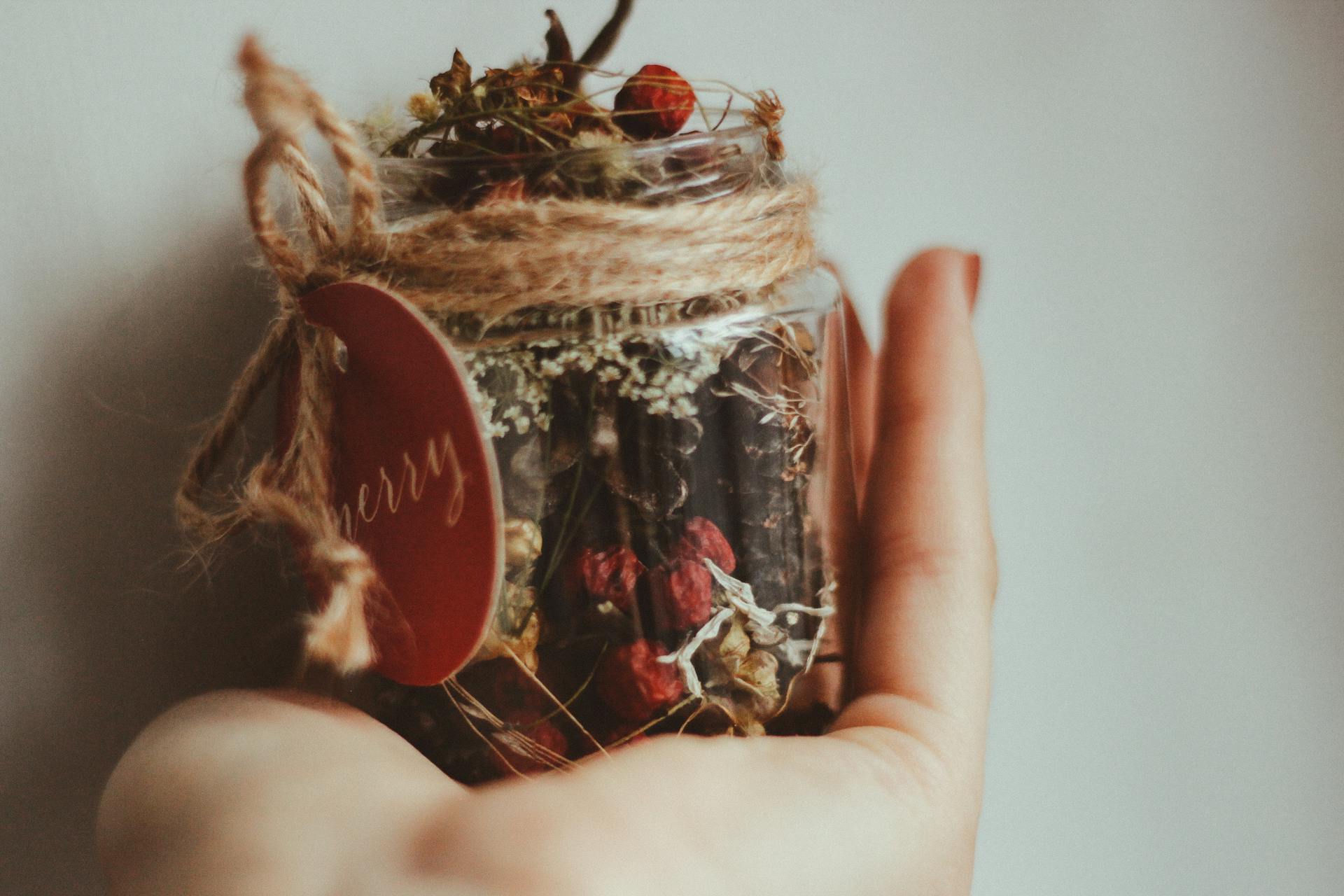 Person Holding Clear Glass Jar