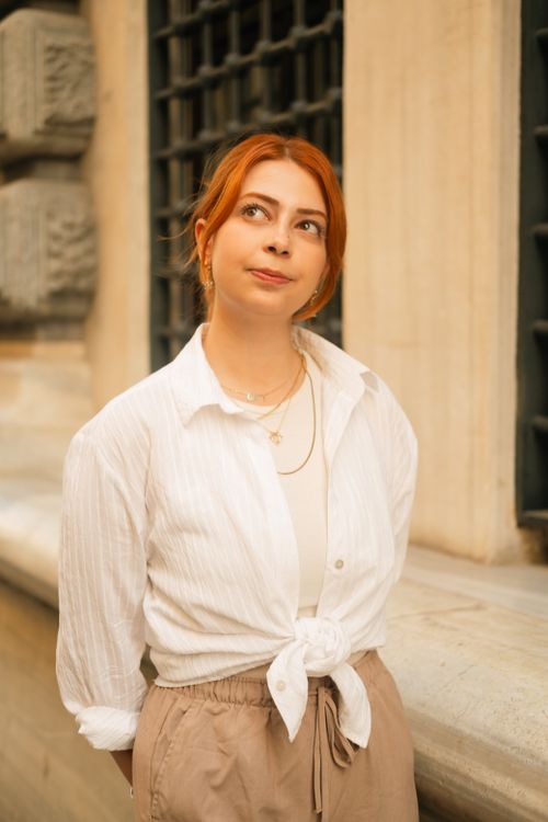 Free Portrait of a stylish woman with red hair in Istanbul, Türkiye, against a textured building background. Stock Photo