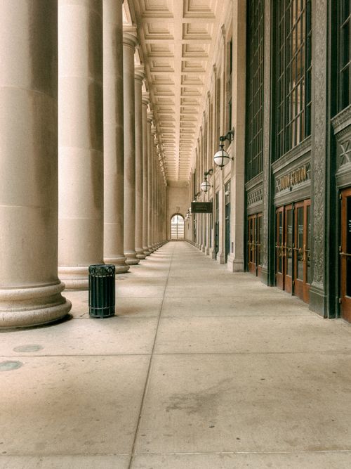 Free Elegant neoclassical architecture with symmetrical columns and a long hallway. Stock Photo