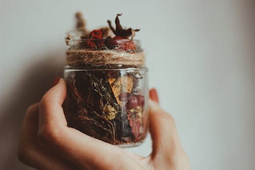 Person Holding Clear Glass Jar