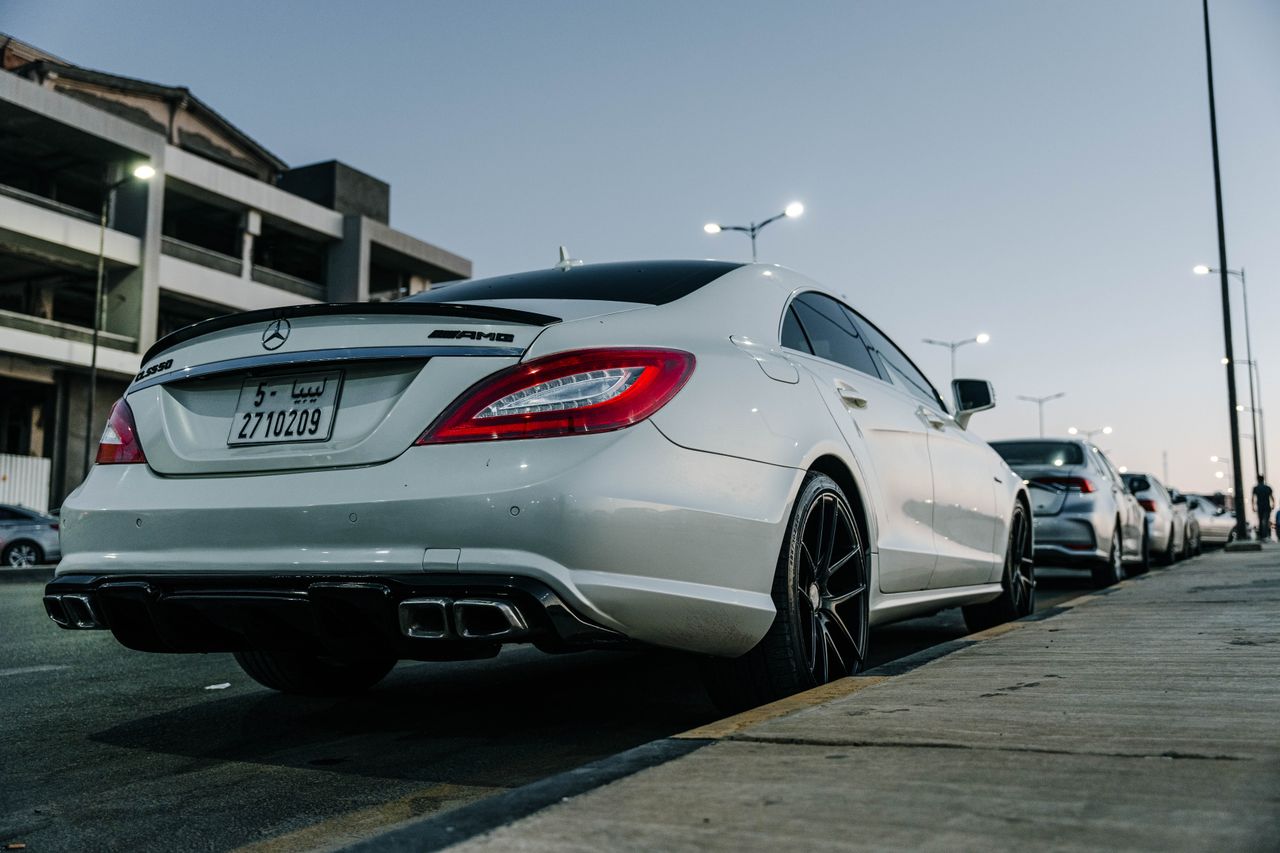 white mercedes benz cls parked on an urban street in tripoli showcasin