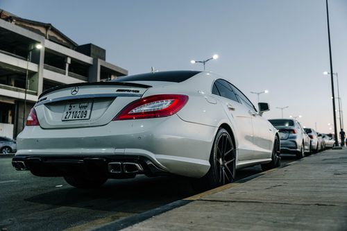 Free White Mercedes Benz CLS parked on an urban street in Tripoli, showcasing sleek design against a twilight backdrop. Stock Photo