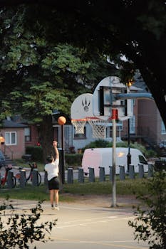 A teenager shoots a basketball during an outdoor twilight game in Toronto.