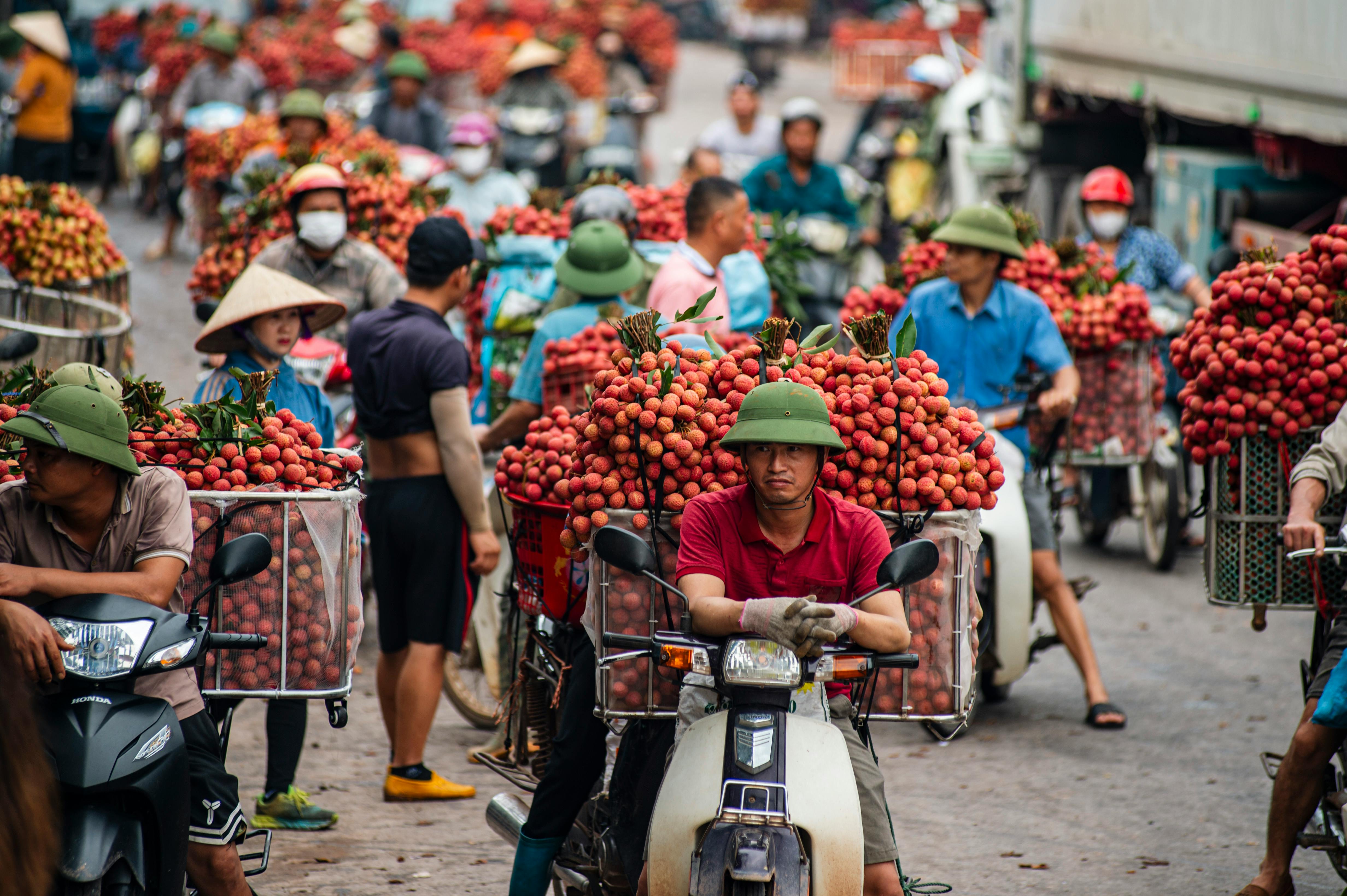 Scène vibrante de la saison des litchis à Bac Giang, Vietnam, capturant l'énergie du marché local.