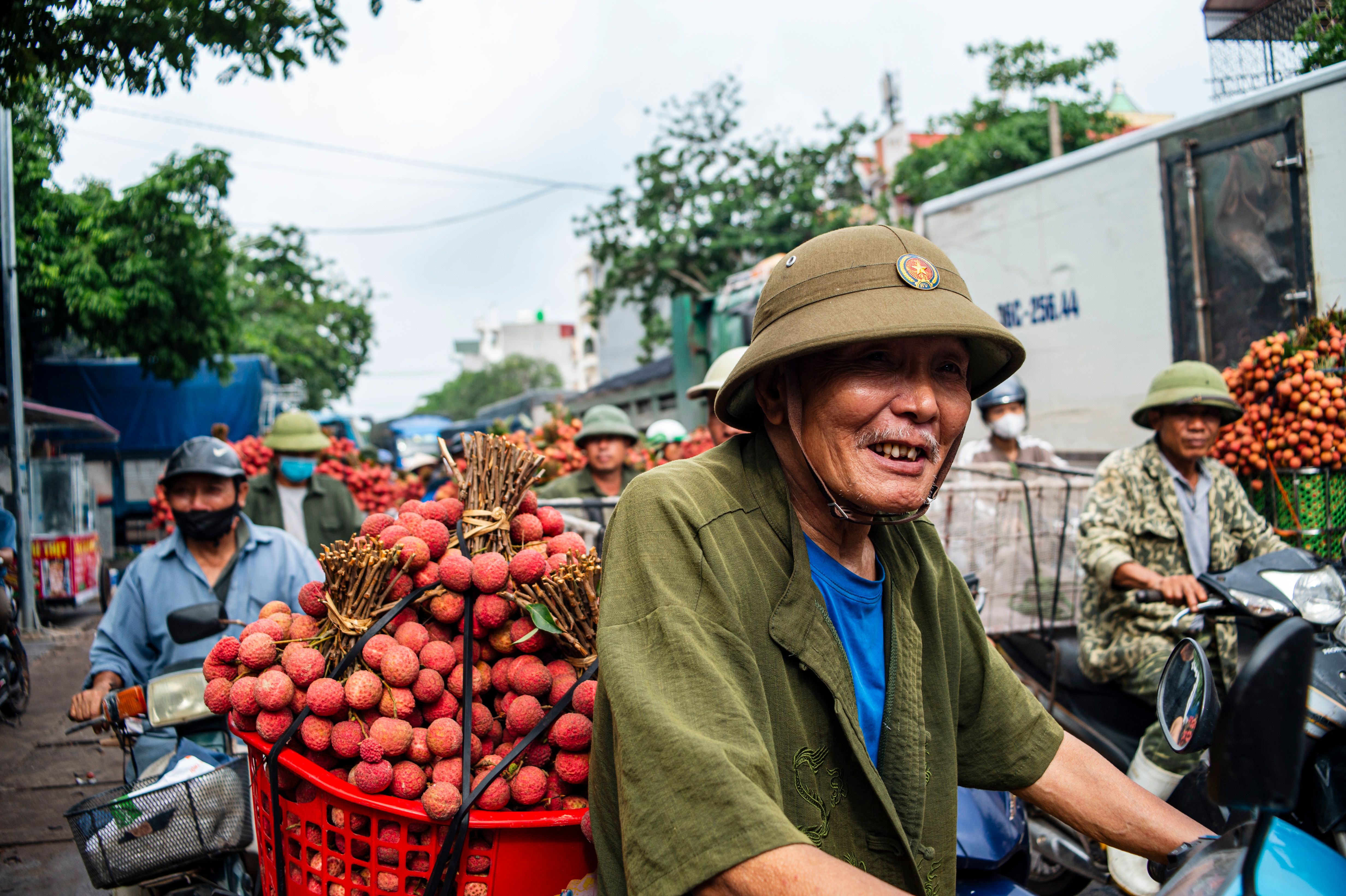 Vibrant street market in Bac Giang, Vietnam during lychee season, featuring locals selling fresh lychees.