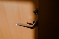 木门上，一个时尚的银色门把手和锁被温暖的光线照亮