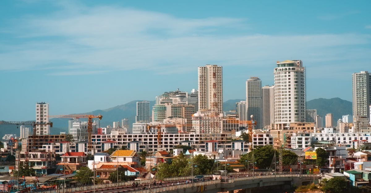 Panoramic view of urban skyline with skyscrapers and bridge in daylight.