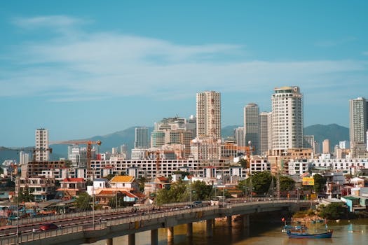 Panoramic view of urban skyline with skyscrapers and bridge in daylight.