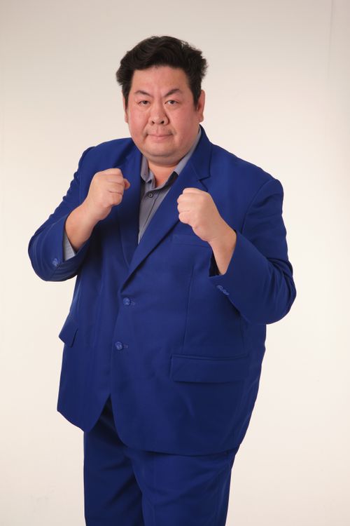 Free Portrait of a confident man in a striking blue suit with fists up, ready for action. Stock Photo