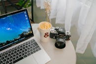 Modern Workspace with Laptop, Camera, and Coffee