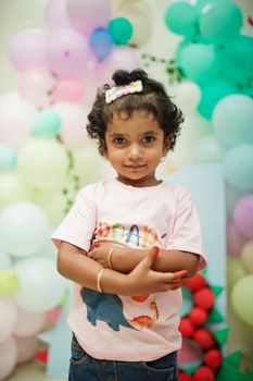 Cute child enjoying a dinosaur-themed birthday celebration indoors.