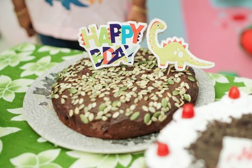 Free A fun dinosaur-themed birthday cake with colorful decorations and seeds. Stock Photo