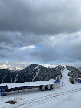 Winter snow scene at the picturesque Malam Jabba resort with dramatic clouds and snowy peaks.