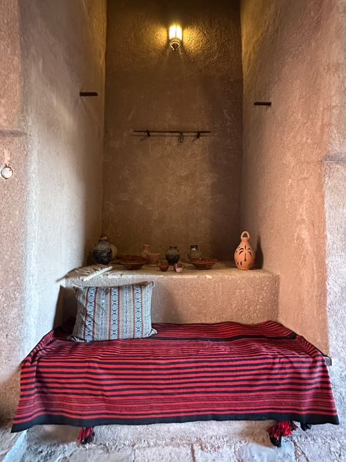Free A cozy traditional Omani interior featuring decorative pottery and textiles in warm lighting. Stock Photo